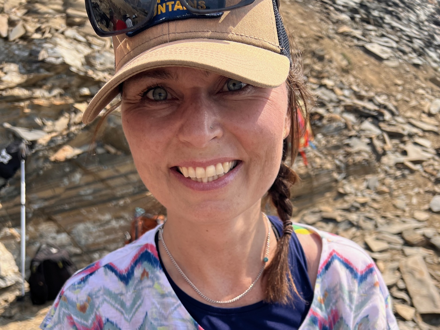 Image of women with a quarry of shale rocks behind her